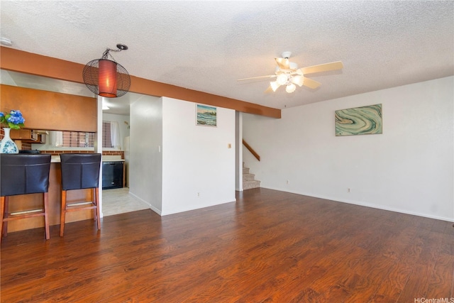 92-1044 Kanehoa Loop Unit 84, Kapolei, HI 96707 - unfurnished living room with a ceiling fan, wood finished floors, stairway, a textured ceiling, and baseboards