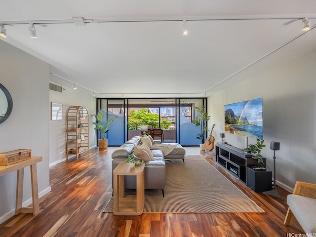 living area featuring rail lighting, wood finished floors, and baseboards