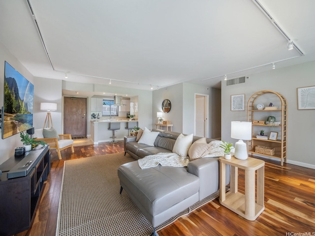 living room featuring rail lighting and wood finished floors