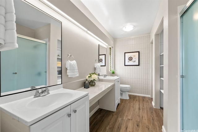 214 Koko Isle Cir Unit 1707, Honolulu, HI 96825 - bathroom featuring tile walls, wood finished floors, a shower with door, vanity, and toilet