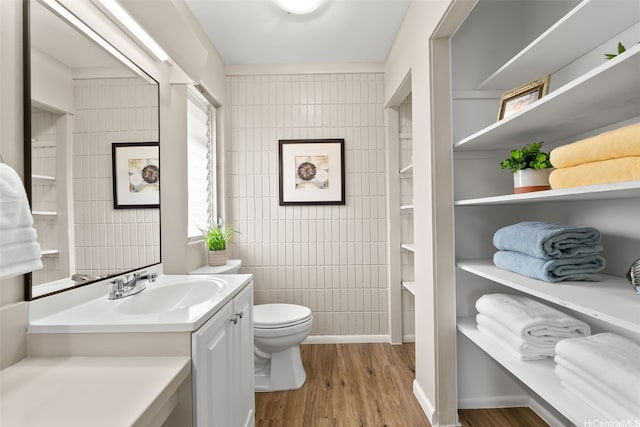 214 Koko Isle Cir Unit 1707, Honolulu, HI 96825 - bathroom featuring wood finished floors, tile walls, toilet, and vanity
