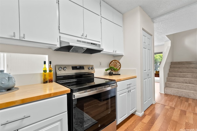 214 Koko Isle Cir Unit 1707, Honolulu, HI 96825 - kitchen featuring under cabinet range hood, stainless steel electric stove, butcher block counters, light wood finished floors, and white cabinets