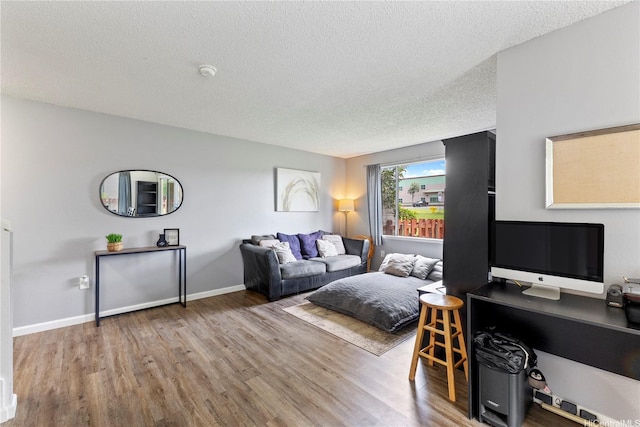 95-1049 Kuauli St Unit 49, Mililani, HI 96789 - living area with a textured ceiling, wood finished floors, baseboards, and a desk