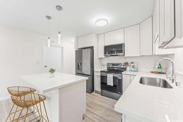 47-599 Alawiki St, Kaneohe, HI 96744 - kitchen featuring appliances with stainless steel finishes, a sink, a kitchen island, and light wood-style flooring
