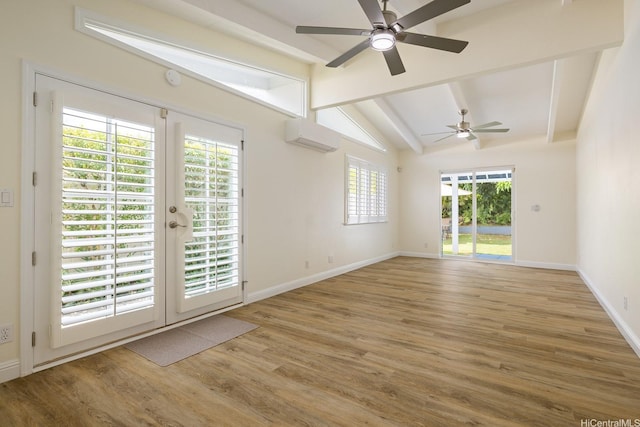 empty room with a ceiling fan, wood finished floors, a wall mounted air conditioner, and baseboards