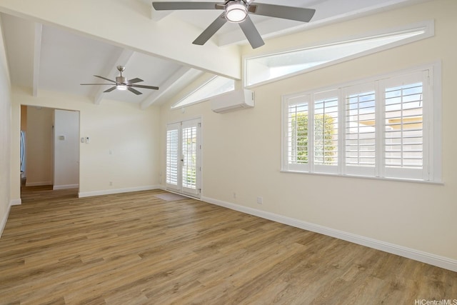 spare room with a wall unit AC, a ceiling fan, light wood-type flooring, and baseboards