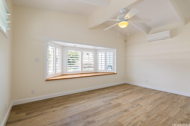 unfurnished room featuring an AC wall unit, wood finished floors, ceiling fan, and baseboards