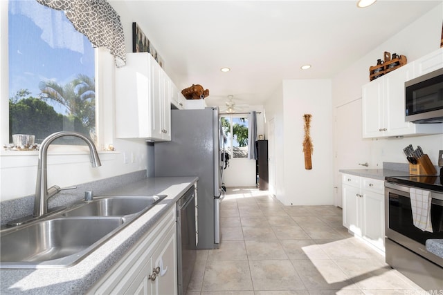 92-7049 Elele St Unit 29, Kapolei, HI 96707 - kitchen with appliances with stainless steel finishes, a sink, a ceiling fan, light tile patterned floors, and white cabinets