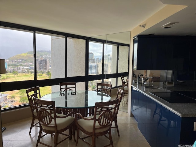 sunroom / solarium with a city view, a sink, and healthy amount of natural light