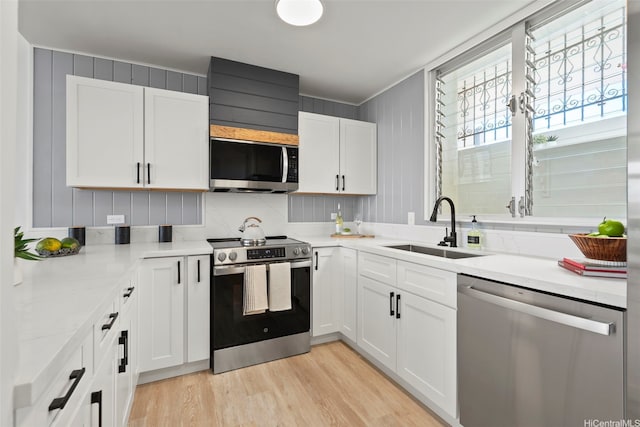 500 University Ave Unit Ph6, Honolulu, HI 96826 - kitchen featuring appliances with stainless steel finishes, a sink, white cabinetry, and light wood-style flooring