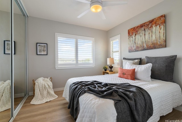 bedroom featuring wood finished floors, baseboards, and ceiling fan
