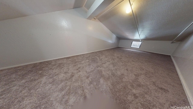 additional living space with lofted ceiling, carpet floors, a textured ceiling, and baseboards