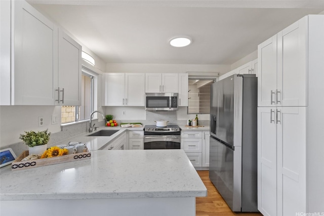 98-533 Kipaepae St Unit 104, Aiea, HI 96701 - kitchen featuring stainless steel appliances, a sink, white cabinetry, light stone countertops, and light wood finished floors
