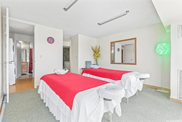 bedroom with carpet flooring, a textured ceiling, and baseboards