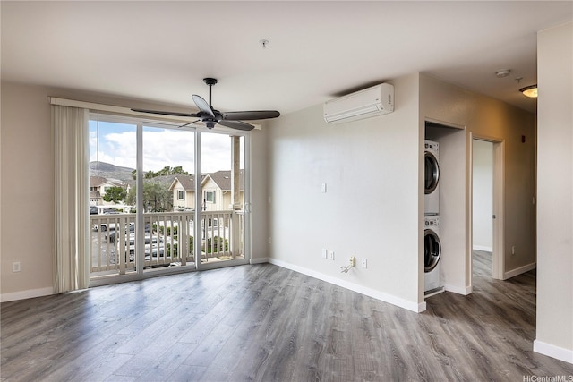 1020 Kakala St Unit 914, Kapolei, HI 96707 - unfurnished living room featuring a wall unit AC, stacked washing machine and dryer, a ceiling fan, wood finished floors, and baseboards