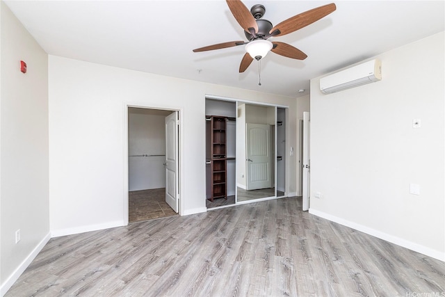 1020 Kakala St Unit 914, Kapolei, HI 96707 - unfurnished bedroom featuring a wall unit AC, wood finished floors, a closet, and baseboards