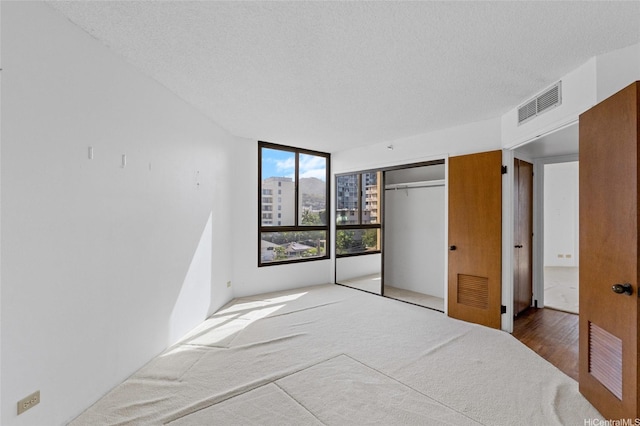 1040 Lunalilo St Unit 706, Honolulu, HI 96822 - unfurnished bedroom featuring carpet, a textured ceiling, and a closet