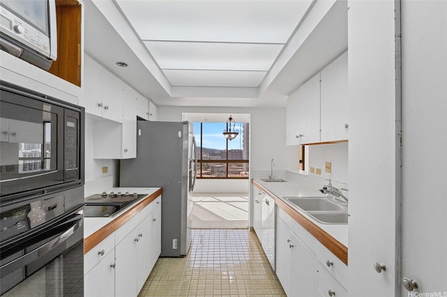 1040 Lunalilo St Unit 706, Honolulu, HI 96822 - kitchen with black appliances, a sink, white cabinets, and light countertops