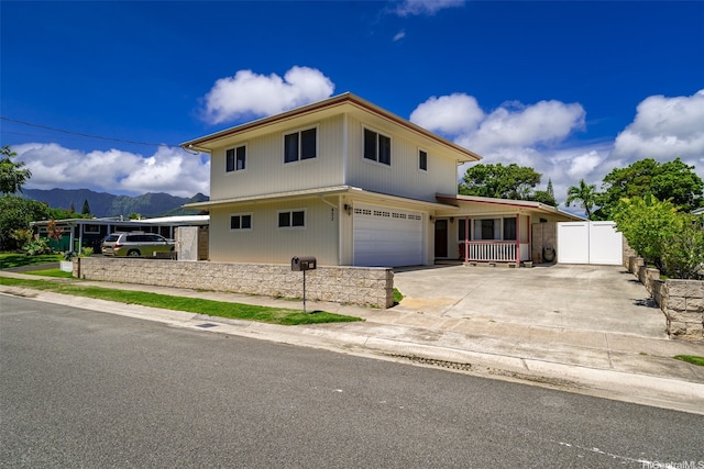 622 Pamaele St, Kailua, HI 96734 - view of front of home with a mountain view, a garage, a porch, concrete driveway, and fence