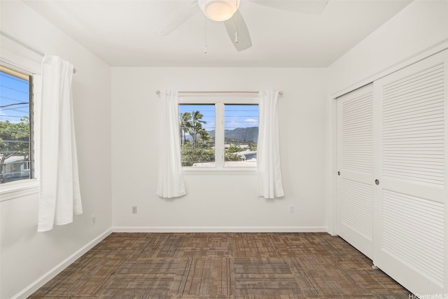 622 Pamaele St, Kailua, HI 96734 - unfurnished bedroom with multiple windows, a closet, a ceiling fan, and baseboards