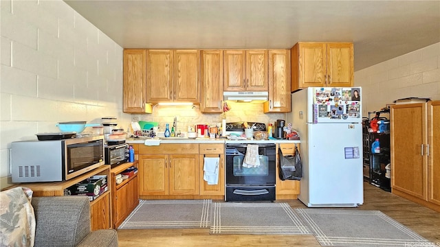 2122 Lime St Unit 307, Honolulu, HI 96826 - kitchen featuring electric range, freestanding refrigerator, stainless steel microwave, under cabinet range hood, and light wood-style floors