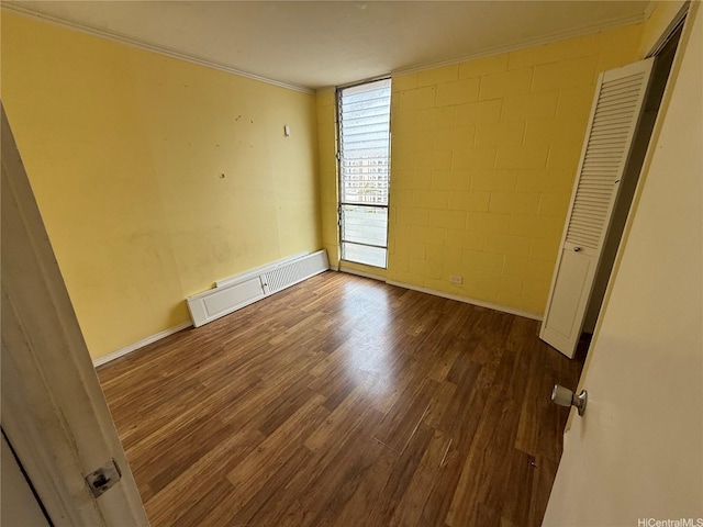 1440 Ward Ave Unit 402, Honolulu, HI 96822 - unfurnished bedroom with wood finished floors, ornamental molding, concrete block wall, and baseboards