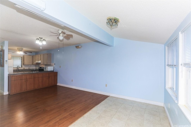 95-1050 Makaikai St Unit 23D, Mililani, HI 96789 - kitchen with white appliances, a ceiling fan, dark countertops, a sink, and brown cabinetry