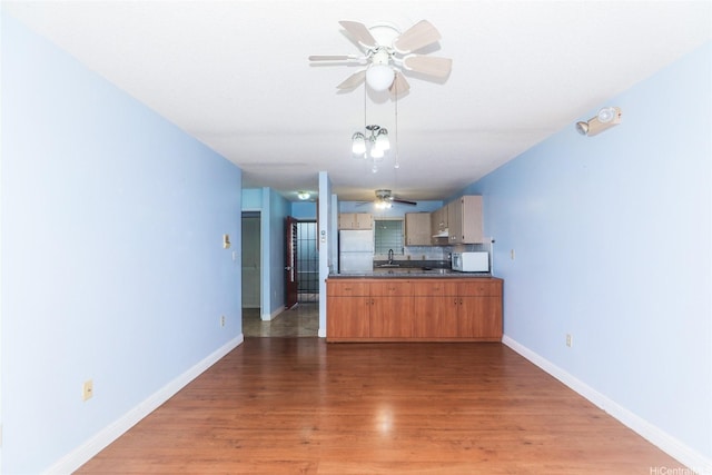 95-1050 Makaikai St Unit 23D, Mililani, HI 96789 - kitchen featuring a ceiling fan, white appliances, dark countertops, light wood-style floors, and baseboards