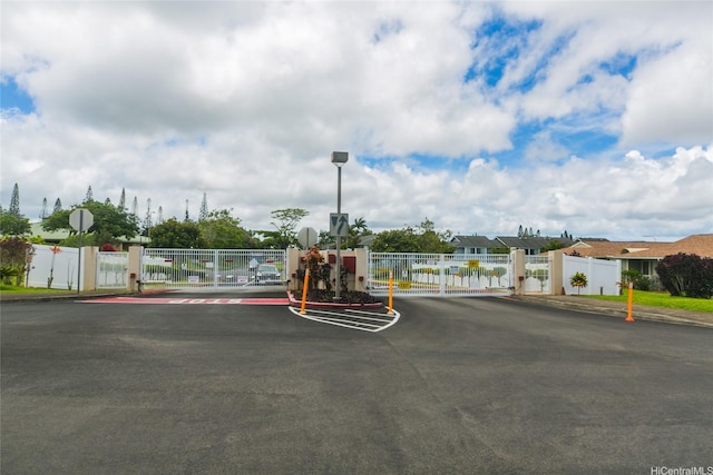 95-1050 Makaikai St Unit 23D, Mililani, HI 96789 - view of asphalt street with a gate, traffic signs, street lights, and a gated entry