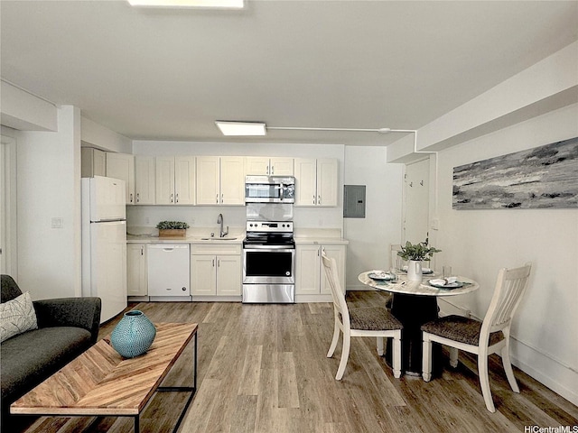410 Nahua St Unit 302, Honolulu, HI 96815 - kitchen with appliances with stainless steel finishes, a sink, electric panel, light countertops, and light wood-type flooring