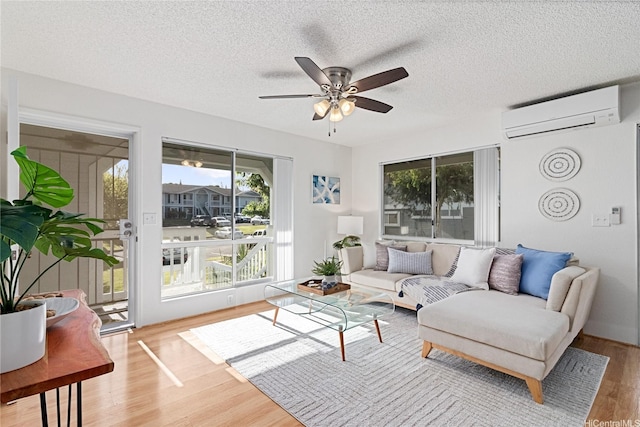 94-820 Lumiauau St Unit G201, Waipahu, HI 96797 - living room with a wall mounted AC, plenty of natural light, a ceiling fan, wood finished floors, and a textured ceiling