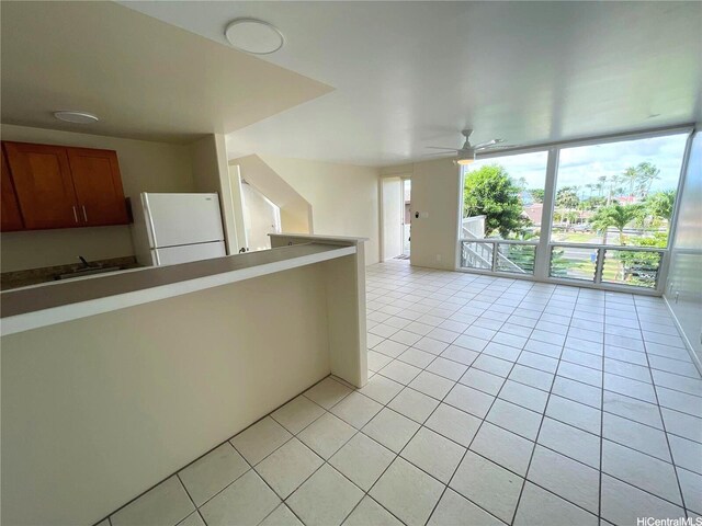 47-218 Kamehameha Hwy, Kaneohe, HI 96744 - kitchen with freestanding refrigerator, light tile patterned floors, a wall of windows, a ceiling fan, and brown cabinets