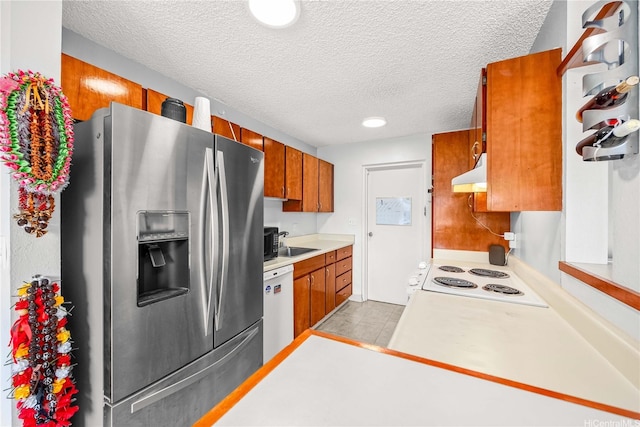 46-049 Aliianela Pl Unit 1713, Kaneohe, HI 96744 - kitchen with white appliances, under cabinet range hood, a textured ceiling, brown cabinetry, and light countertops