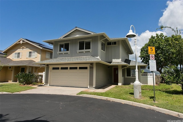 87-2233 Pakeke St, Waianae, HI 96792 - view of front of house with an attached garage, concrete driveway, a front lawn, and board and batten siding