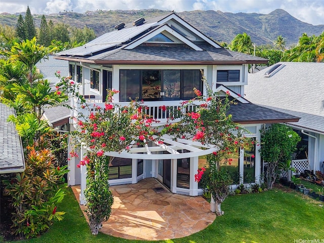 382 Kuanalu Pl, Honolulu, HI 96825 - back of house with a mountain view, a yard, roof with shingles, a patio area, and roof mounted solar panels