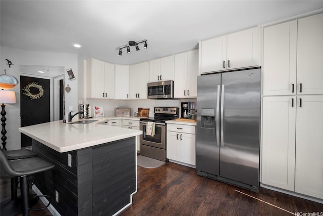 91-422 Makalea St Unit 94, Ewa Beach, HI 96706 - kitchen featuring stainless steel appliances, a sink, a peninsula, a breakfast bar area, and dark wood finished floors
