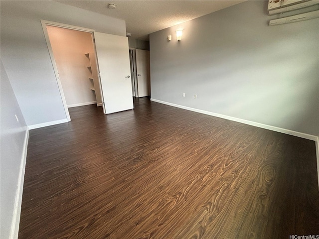 801 S St Unit 1723, Honolulu, HI 96813 - unfurnished room with dark wood-type flooring, baseboards, a smoke detector, and a wall mounted air conditioner