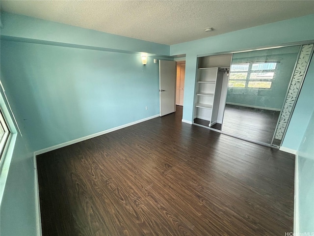 801 S St Unit 1723, Honolulu, HI 96813 - unfurnished bedroom with dark wood-style floors, baseboards, a textured ceiling, and a closet