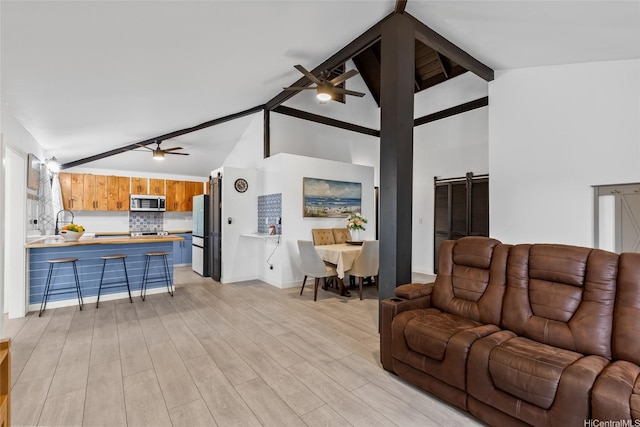 94-265 Anania Dr, Mililani, HI 96789 - living room with a ceiling fan, beamed ceiling, a barn door, light wood-style flooring, and high vaulted ceiling
