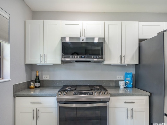 91-1066 Makaaloa St Unit 14D, Ewa Beach, HI 96706 - kitchen with stainless steel appliances, white cabinetry, and dark countertops