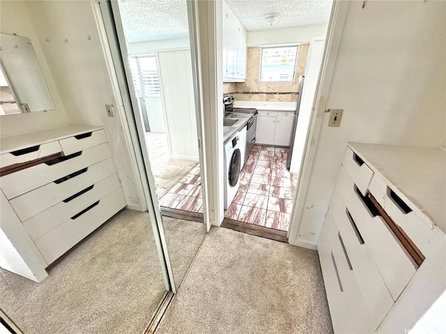 410 Nahua St Unit 404, Honolulu, HI 96815 - laundry room featuring a textured ceiling, light carpet, and washing machine and dryer