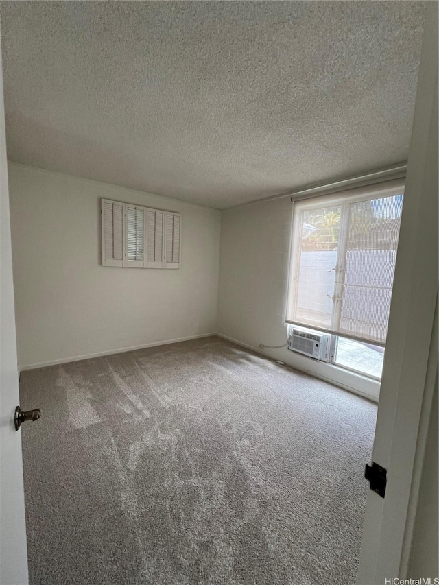 118 Kalalau St, Honolulu, HI 96825 - carpeted empty room featuring a textured ceiling, a wall unit AC, and baseboards