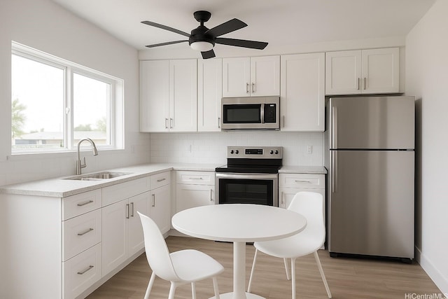 51-470 Lihimauna Rd, Kaaawa, HI 96730 - kitchen with appliances with stainless steel finishes, a sink, backsplash, white cabinets, and light wood-type flooring