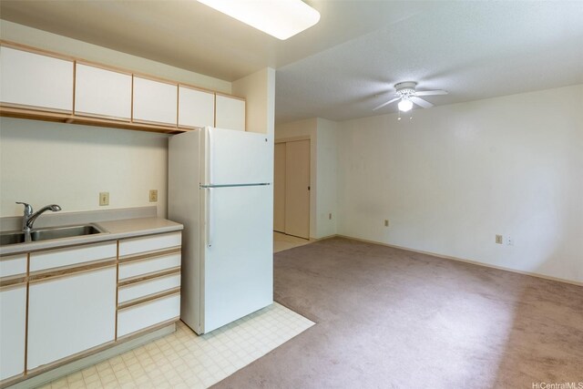 95-1045 Kaapeha St Unit 172, Mililani, HI 96789 - kitchen featuring freestanding refrigerator, ceiling fan, a sink, light colored carpet, and light countertops