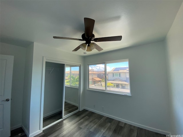 91-1001 Keaunui Dr Unit 441, Ewa Beach, HI 96706 - unfurnished bedroom with dark wood finished floors, a closet, baseboards, and a ceiling fan