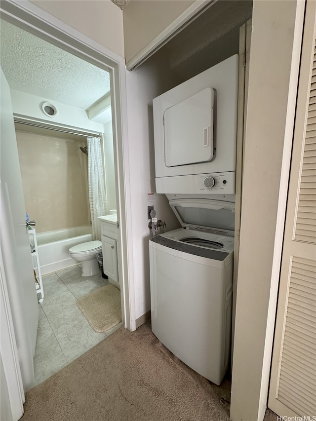 1778 Ala Moana Blvd Unit 1502, Honolulu, HI 96815 - laundry room with stacked washer / drying machine, light carpet, a textured ceiling, and light tile patterned floors