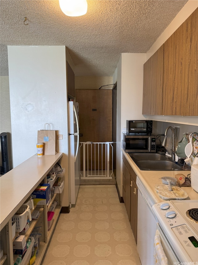 1778 Ala Moana Blvd Unit 1502, Honolulu, HI 96815 - kitchen featuring freestanding refrigerator, a sink, a textured ceiling, light floors, and light countertops