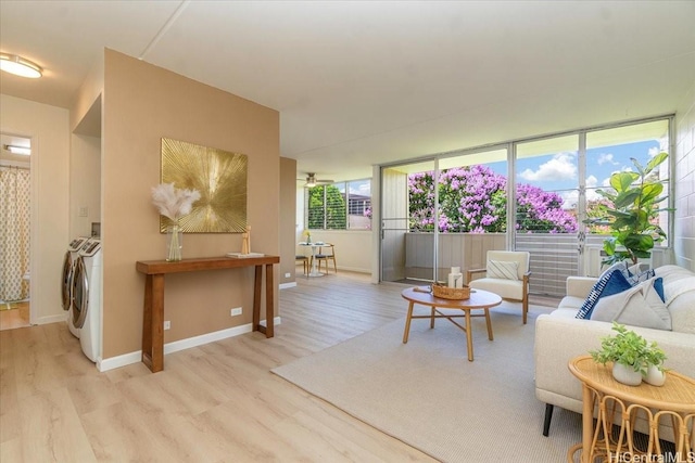 94-327 Hokuahiahi St Unit 325, Mililani, HI 96789 - living room featuring washing machine and clothes dryer, light wood-style floors, and baseboards