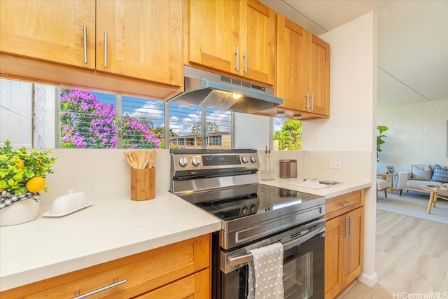 94-327 Hokuahiahi St Unit 325, Mililani, HI 96789 - kitchen featuring stainless steel range with electric stovetop, under cabinet range hood, light countertops, light wood finished floors, and tasteful backsplash