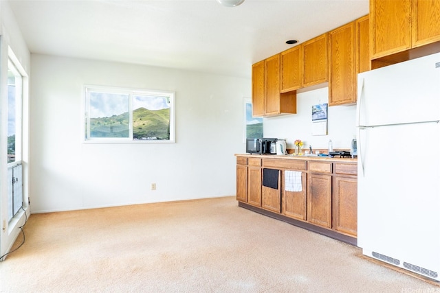 1164 Manulani St, Kailua, HI 96734 - kitchen featuring freestanding refrigerator, light carpet, light countertops, and brown cabinets